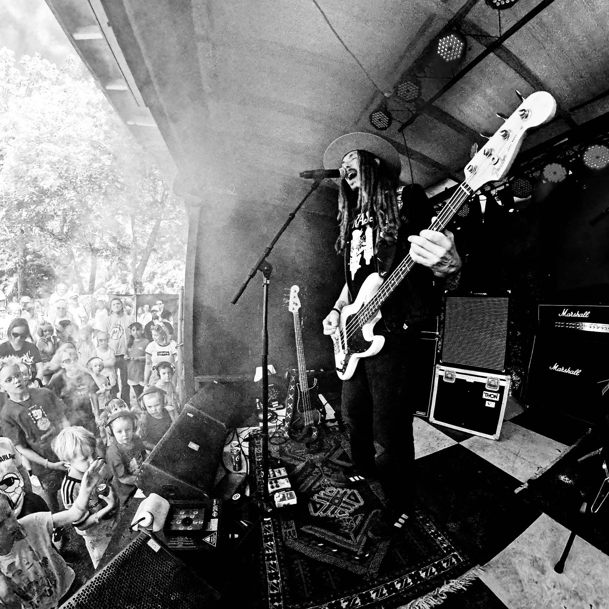 Bassisten i TRASS synger på scenekanten med barn i front