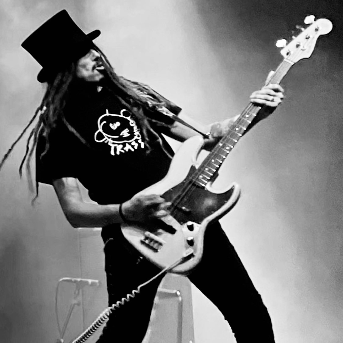 Bassisten i TRASS med hatt og bass på scenen