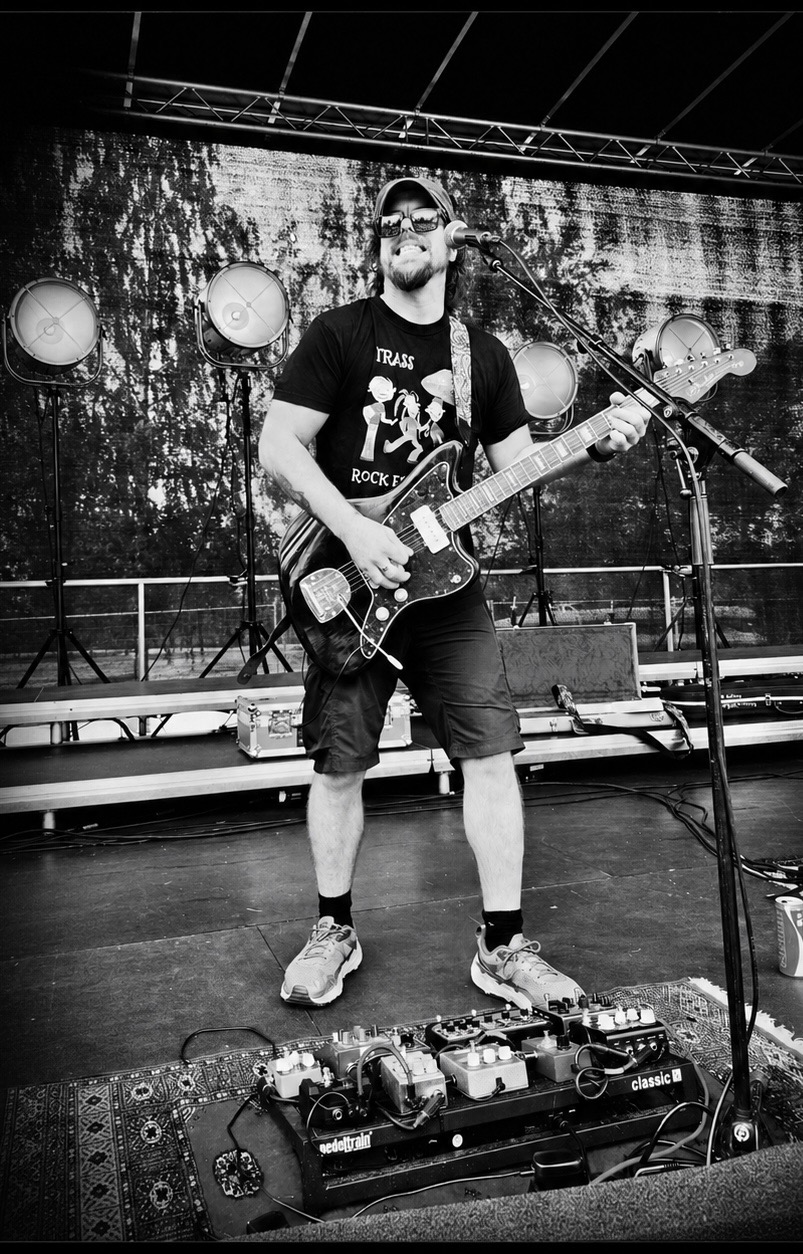 Gitarist synger i mikrofonen på scenen